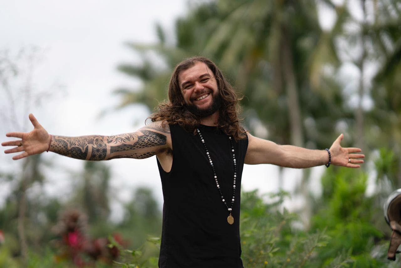 Joshua Sting standing with arms open, smiling