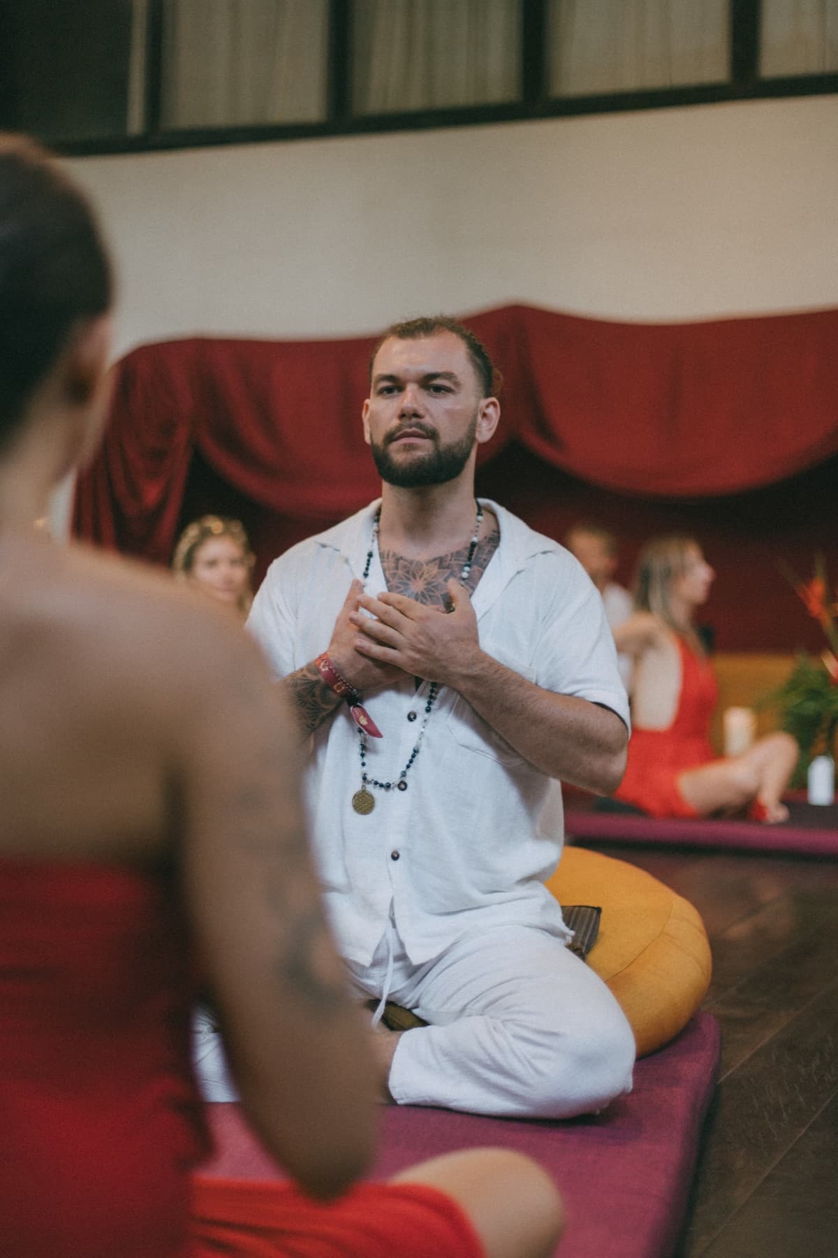 Joshua Sting kneeling with his hands on his heart in a ceremony setting